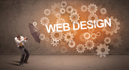 Businessman defending with umbrella from WEB DESIGN inscription, technology concept