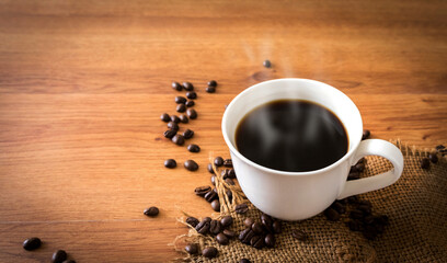cup of coffee and coffee beans on old wooden background.