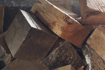 Close up of a firewood pile with a cross-section of wooden blocks.