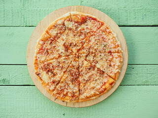 pizza on a wooden green background. Italian kitchen