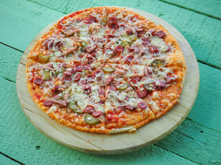 pizza on a wooden green background. Italian kitchen