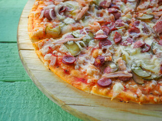 pizza on a wooden green background. Italian kitchen