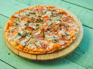 pizza on a wooden green background. Italian kitchen