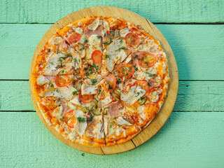 pizza on a wooden green background. Italian kitchen