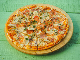 pizza on a wooden green background. Italian kitchen