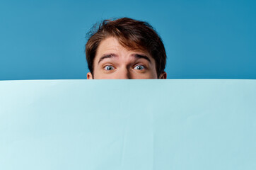 a man peeking out from behind a banner close-up advertising Copy Space marketing