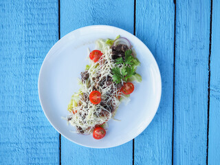 Meat salad on blue wooden background