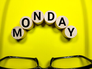 Selective focus.Glasses and cylinder block with word MONDAY on yellow background.Shot were noise...