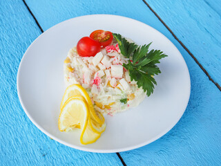 Olivier salad on a blue wooden background