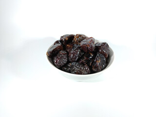 Selective focus.Dried sweet dates on bowl isolated on white background. Healthy food concept.
