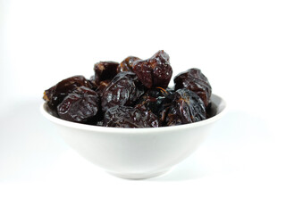 Selective focus.Dried sweet dates on bowl isolated on white background. Healthy food concept.