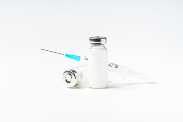 Close up glass vial with flu vaccine and syringe with needle. The concept of vaccination or preventive treatment of injection diseases.