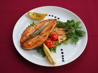 Baked salmon in foil on a red background
