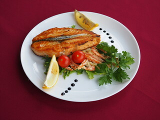 Baked salmon in foil on a red background