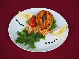 Baked salmon in foil on a red background