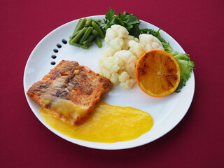 Baked salmon in foil on a red background
