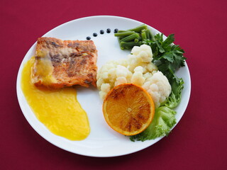 Baked salmon in foil on a red background