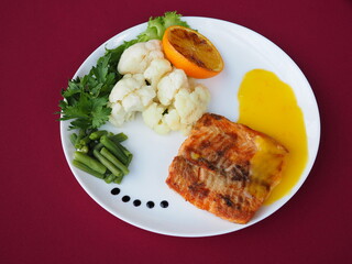 Baked salmon in foil on a red background