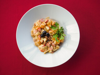 Sausage salad on red background
