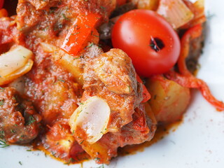 Beefsteak with tomato and herbs on a red background
