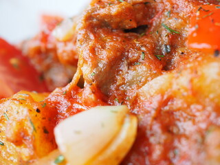 Beefsteak with tomato and herbs on a red background