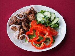 Beefsteak with tomato and herbs on a red background