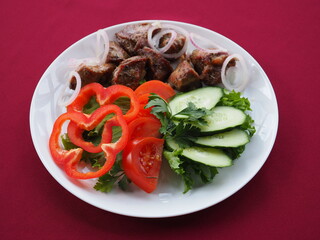 Beefsteak with tomato and herbs on a red background