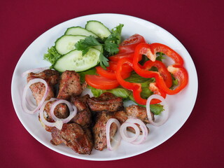 Beefsteak with tomato and herbs on a red background
