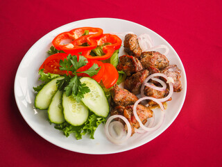 Beefsteak with tomato and herbs on a red background
