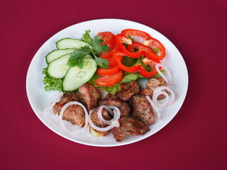 Beefsteak with tomato and herbs on a red background