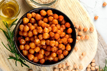 Vegan healthy snack, homemade roasted chickpeas in bowl on light gray background.