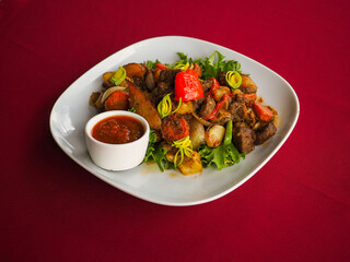 Beefsteak with tomato and herbs on a red background