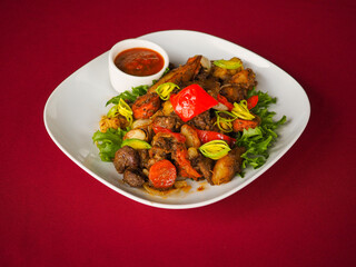 Beefsteak with tomato and herbs on a red background