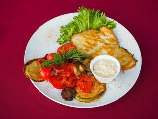 Beefsteak with tomato and herbs on a red background