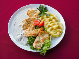 Beefsteak with tomato and herbs on a red background