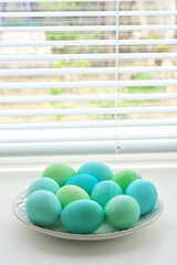 Light blue and green Easter eggs in plate