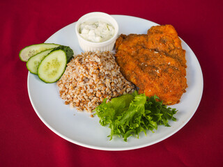 Beefsteak with tomato and herbs on a red background