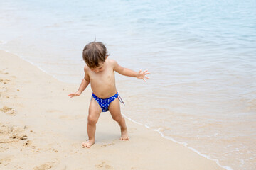adorable toddler toddler run playing on sandy beach of tropical sea