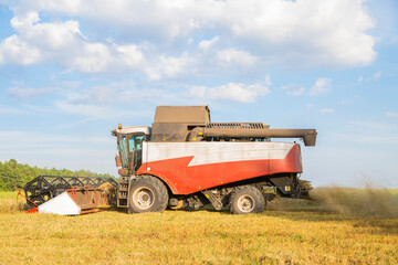 Obraz premium old combine harvester harvests from the field