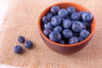 Fresh juicy ripe blueberries in a clay cup. 