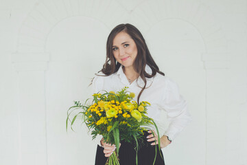 Smiling woman holding yellow flowers bouquet on white background