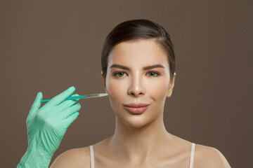 Beauty portrait of attractive woman face with syringe injection. Cosmetology and aesthetic surgery concept