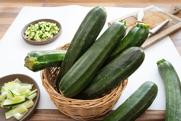 Close-up of courgettes in a wicker basket on a kitchen table