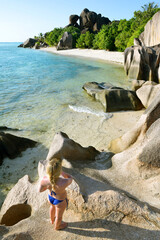 Woman looks at the beach Anse Source d'Argent. La Digue Island, Indian Ocean, Seychelles. Vacations concept.