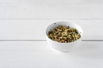 Sprouted mung beans in a bowl on white table. Healthy concept, macrobiotic food.