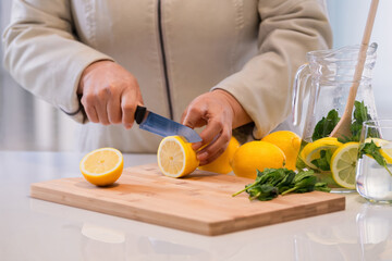 Cutting lemons on a cutting board with mint leaves