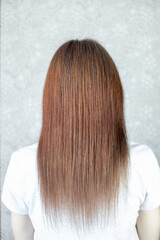 A girl with long, straight and beautiful brown hair. Hair care at home