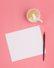 note paper with cup of coffee and ink pen on pink background 