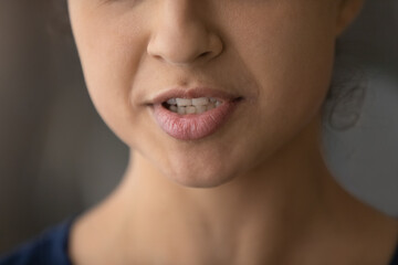 Crop close up of lower face of young Indian woman speak talk. Closeup of millennial mixed race...