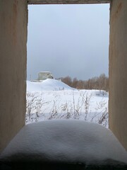 Ruins of an old building with a window hole and the remnants of a window frame, covered with snow (Im. V.i. Lenina, Ulyanovsk Oblast, Russia)